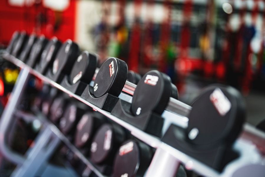 Woman standing surrounded by exercise equipment